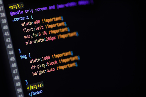 Laptop screen showing HTML and CSS code